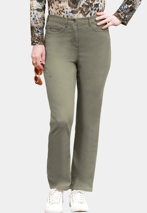 Pantalon droit vert olive avec une fermeture à bouton et des poches avant. Porté avec un haut à motifs et des baskets blanches. Texture de tissu lisse.