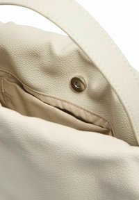 Vaaleanbeige käsilaukku, jossa on teksturoitu nahkapinta, pehmeä kangasvuori ja sisäpuolella näkyvä napeilla suljettava kiinnitys.