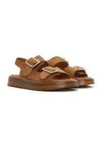 Brown suede sandals with open toes and double adjustable buckle straps. Thick, solid brown rubber soles provide cushioning and support.