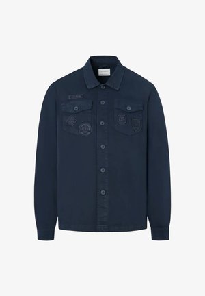 Camisa chaqueta azul marino con botones, mangas largas, dos bolsillos en el pecho con solapa y parches decorativos bordados en los bolsillos delanteros.