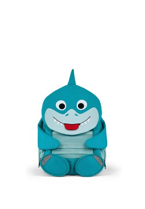Blauer Kinderrucksack, gestaltet als lächelnder Hai mit großen Augen, Flosse oben, kleinen Armen und Füßen, der aufrecht sitzt.