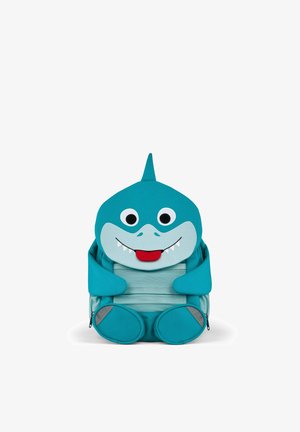 Blauer Kinderrucksack, gestaltet als lächelnder Hai mit großen Augen, Flosse oben, kleinen Armen und Füßen, der aufrecht sitzt.
