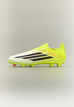 Felgele Adidas F50 voetbalschoen met zwarte strepen, zachte sokachtige kraag en gevormde noppen op een neutrale achtergrond.