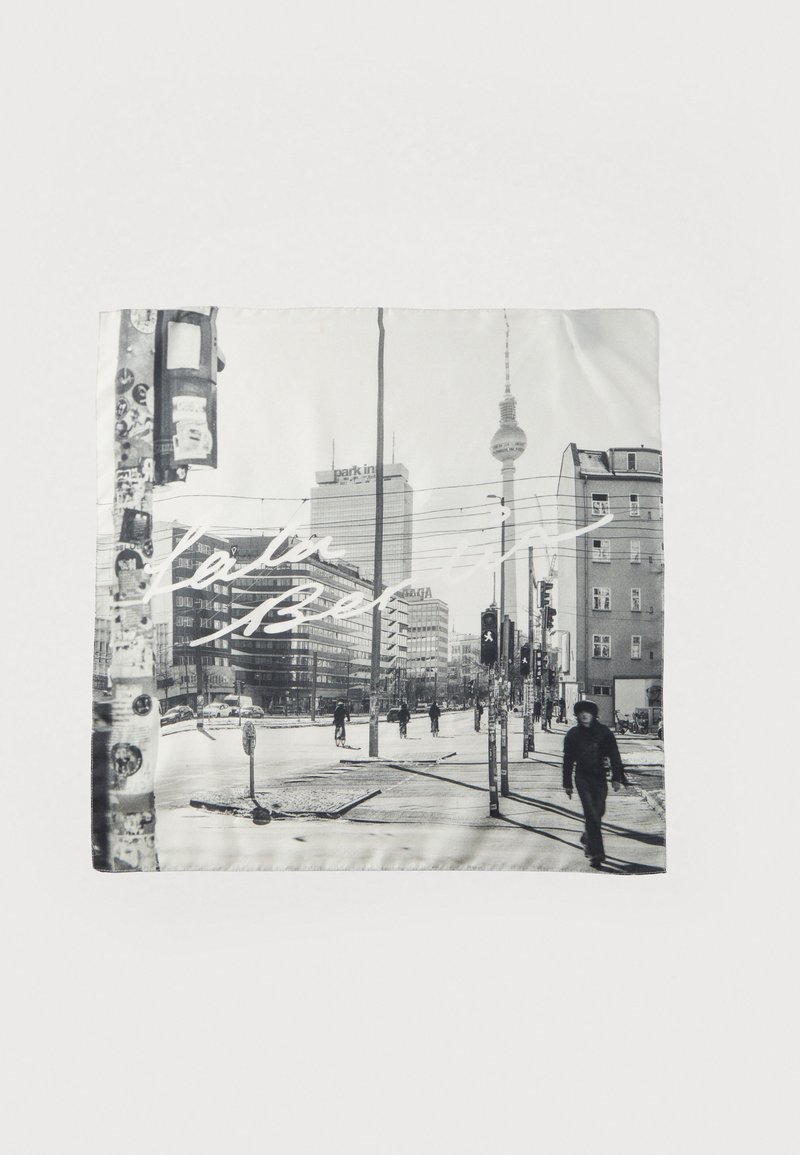 Μαύρο και λευκό μεταξωτό φουλάρι που απεικονίζει τοπία πόλης με κτίρια, φωτεινούς σηματοδότες και πεζούς, με επίστρωση λευκού κειμένου.