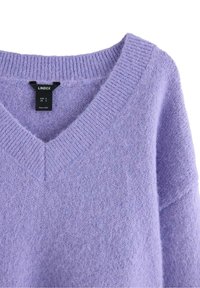 Maglione lavorato a maglia lilla con scollatura a V, caratterizzato da una morbida texture e dettagli a costine sul colletto e sui polsini. Etichetta del marchio visibile.