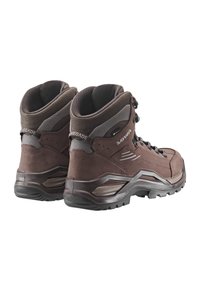 Braune Wanderschuhe mit einem Obermaterial aus Wildleder und Mesh, hoher Knöchelunterstützung, Metallösen, strukturiertem Gummisohle und verstärkter Zehenkappe.