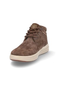 Botas de ante marrón hasta el tobillo con punta redonda, superficie texturizada y suela beige. Presentan cordones marrones y un parche con el logo en la lengüeta.