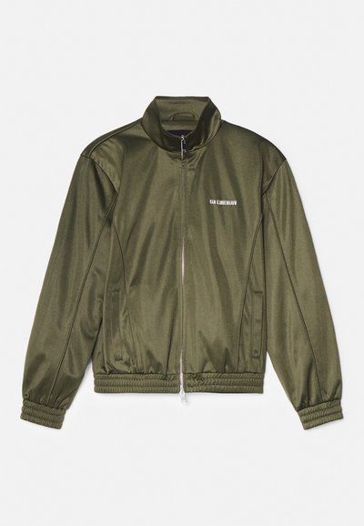 Μπουφάν μπόμπερ από σατέν σε ελιά, με ψηλό γιακά, κλείσιμο με φερμουάρ, ελαστική ζώνη και ριμπ μανσέτες. Διαθέτει λογότυπο στο στήθος.