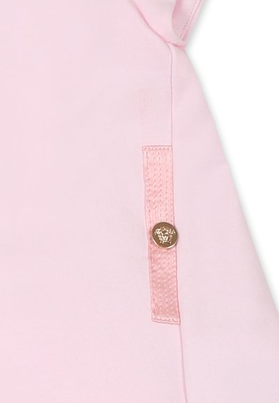 Tessuto rosa con una texture liscia, caratterizzato da una tasca laterale decorata con un bottone dorato tondo e un accento cucito.