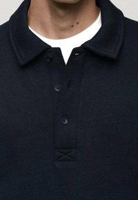 Námořnické polo tričko s límečkem, třemi knoflíky a nášivkou z texturované látky pod knoflíky. Bavlněná látka s hladkým povrchem.