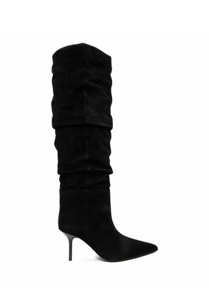 Black suede slouchy knee-high boot with pointed toe and thin mid-height stiletto heel, side view on white background.