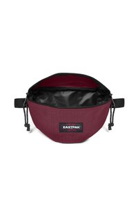 Mörkröd Eastpak-väska med rundad form, svart dragkedjestängning och slätt inre. Har en logotyppatch och justerbar dragsko.