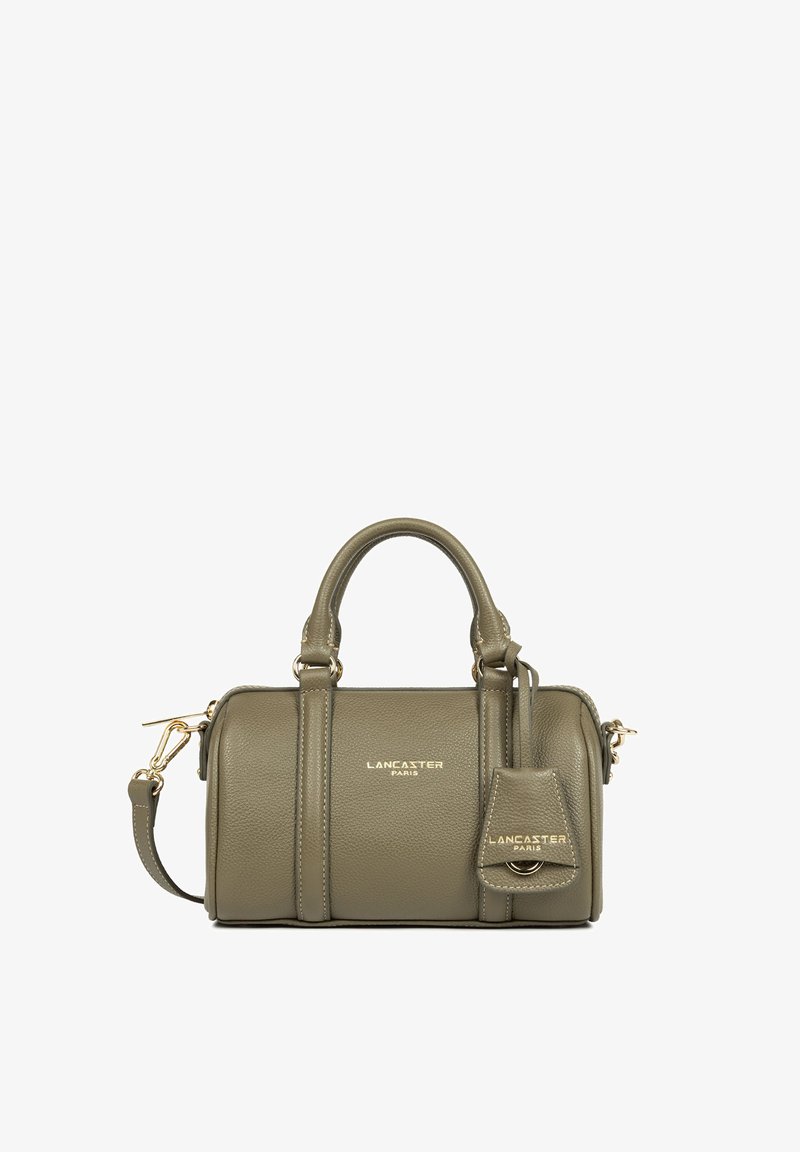 Sac à main en cuir brun verdâtre avec deux poignées supérieures, une bandoulière amovible, des ferrures dorées et le logo Lancaster Paris à l’avant et sur l’étiquette.