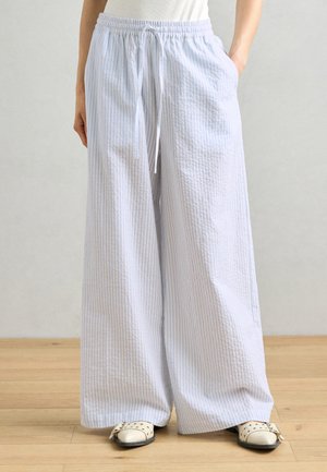 Pantalons à larges jambes rayés bleu clair et blanc avec une taille élastique et un cordon de serrage, fabriqués en tissu texturé et dotés de poches latérales.