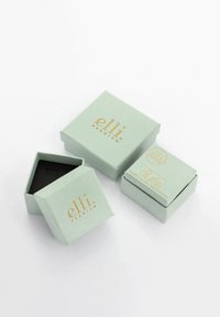 Tre lysegrønne smykkeskrin med gylden "elli premium" branding, en åben, der viser et sort interiør, placeret på en hvid baggrund.