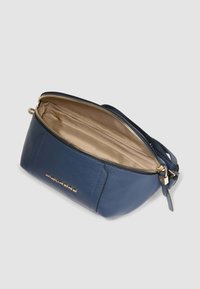 Borsa a tracolla in pelle blu con chiusura a zip, interno beige e hardware color oro. Presenta una forma strutturata e dettagli in rilievo con logo.