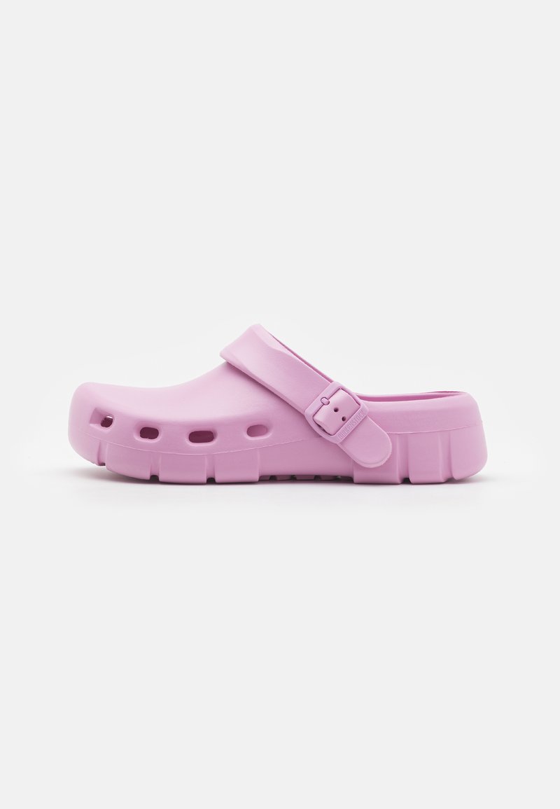 Rosa gummiskoff med bakrem, som har ventilasjonshull og en tykk såle. Glatt tekstur med et minimalistisk design.