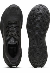Chaussures de sport noires avec une tige en maille texturée, un col rembourré et un système de fermeture à lacets. La semelle extérieure présente un design de grip motifé pour une meilleure adhérence.