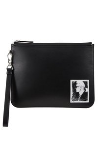 Černé kožené psaníčko s hladkou texturou, vybavené zipem a odnímatelným páskem. Na přední straně je výrazná bílá nášivka s náčrtem.