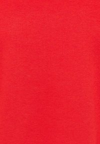 Tissu en tricot rouge uni avec une texture de fil fin visible et de légères variations de teinte sur la surface.