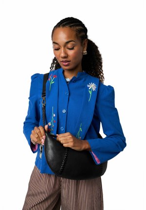 Sinine tikanditega jakk lillemustriga, millele lisandub must nahast hobo-kott õmblusdetailidega. Triibulised püksid annavad komplektile viimase lihvi.