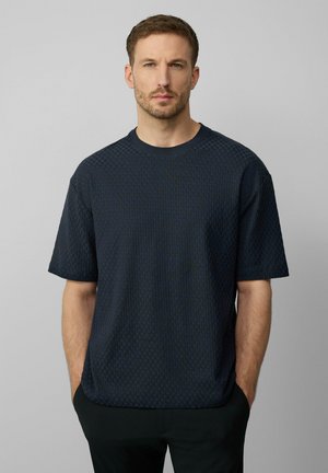 Navy blue short-sleeve sweater made of textured fabric, featuring a round neckline and a relaxed fit, with a subtle pattern across the surface.