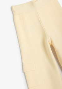 Gule strikstrømpebukser med en ribbet talje og en sidelomme, med en glat tekstur og tætsiddende design.