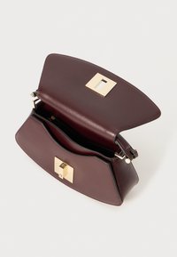 Burgundy leather handbag with a structured shape, gold-tone hardware, a rectangular clasp, and a zippered inner pocket.