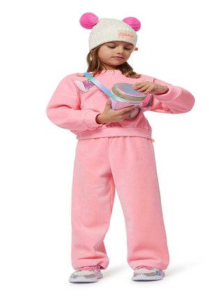 Rosa fleece treningsdress med rund hals, prydet med et glitterhjerte. Outfitet inkluderer en kremfarget strikket lue med rosa pom-pomer.