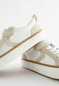 Vita sneakers med beige detaljer, tillverkade av läder och mocka, med en strukturerad sula och klassisk snörning med rem.