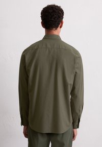 Olijfgroene button-down shirt met lange mouwen, rechte snit, zachte textuur en enkele manchetknoopjes, gezien van de achterkant.
