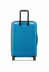 Maleta azul rígida con ranuras verticales, un asa retráctil negra y cuatro ruedas para mayor movilidad. Logo de Delsey Paris en la parte frontal.