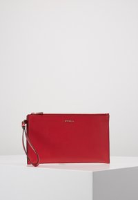 Bolso de mano de cuero rojo con textura granulada, que cuenta con cierre de cremallera y una correa para la muñeca. Logo dorado centrado en el frente.