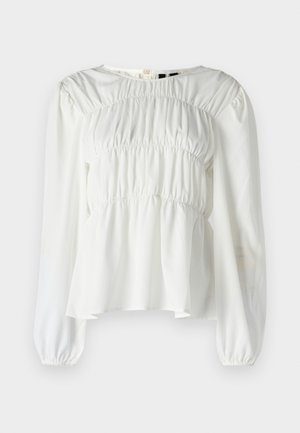 White blouse with a round neckline, long sleeves, and gathered texture at the bodice. Features puffed sleeves and a flowing hemline.