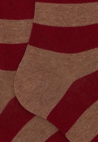 Calzini a righe con bande alternate larghe color bordeaux e beige, realizzati in un morbido materiale a maglia. Dettagli in cucitura nella zona delle dita.