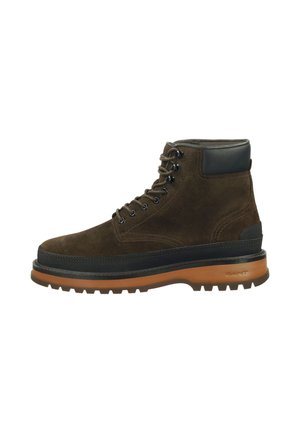 Brown suede boot with black leather accents, round laces, thick rubber sole, and a rugged tread pattern for traction.