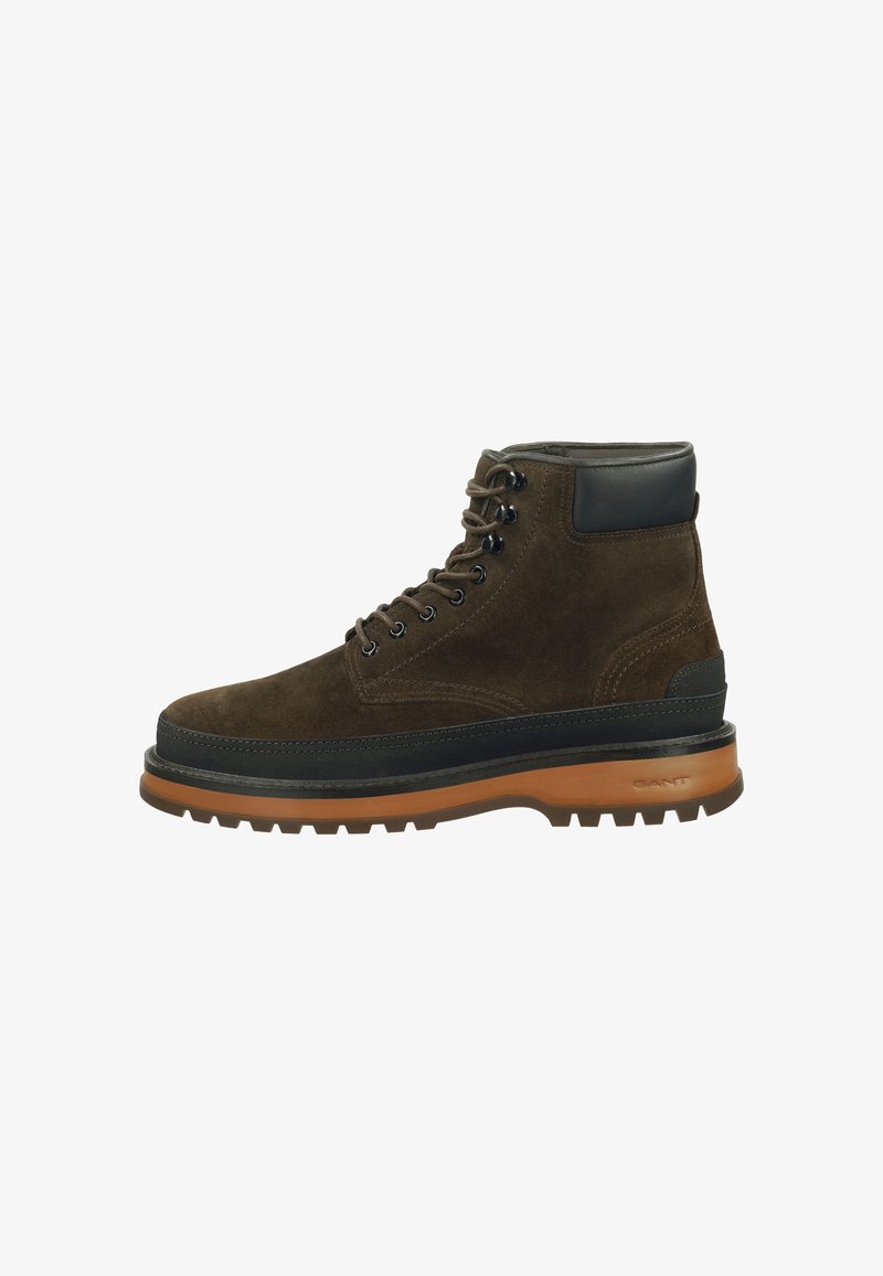 Braune Wildlederstiefel mit schwarzen Lederelementen, runden Schnürsenkeln, dicker Gummisohle und einem robusten Profil für Halt.