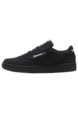 Czarne niskie buty sportowe Reebok z sznurowanym projektem, logo Reebok i flagą Union Jack po stronie oraz teksturowaną podeszwą.