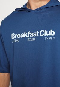 Marineblauer Kurzarm-Hoodie mit "Breakfast Club"-Aufdruck, digitaler Uhranzeige und weichem, glattem Stoff.