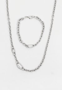 Stříbrný řetízek a náramek, obsahující vzájemně propletené články. Hladký povrch s lesklým dokončením, zobrazující metalický lesk.