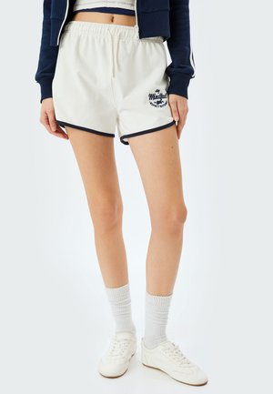 Witte katoenen shorts met marineblauwe accenten en geborduurde "Stay Mindful" logo. Voorzien van een elastische tailleband en een relaxte pasvorm.
