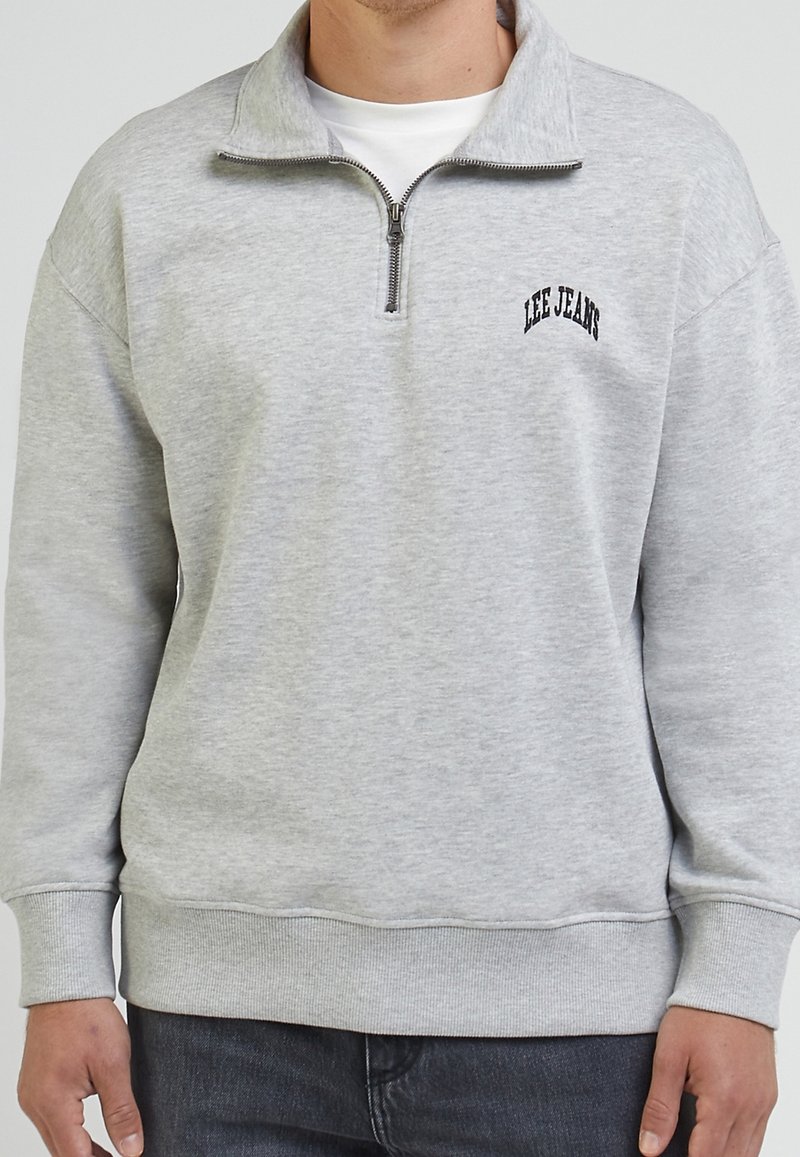 Lichtgrijze sweatshirt met een halve ritssluiting, geribbelde manchetten en zoom. Beschikt over een zwart "LEE JEANS" logo op de linkerkant van de borst. Gemaakt van een katoenmix.