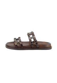Sandalo scivolato in pelle marrone con due cinghie, dotato di accenti metallici decorativi e decorazioni circolari scure. Suola piatta con dettagli di cucitura.