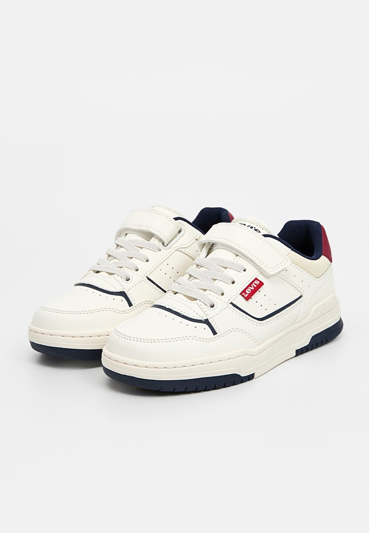 Zapatillas bajas blancas con suelas azul marino, acentos en azul marino y rojo, correas de Velcro y etiquetas del logo rojo de Levi's en los laterales.