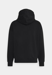 Sudadera con capucha negra de textura suave, con puños y dobladillo acanalados. Presenta un bolsillo canguro y un diseño simple y minimalista.
