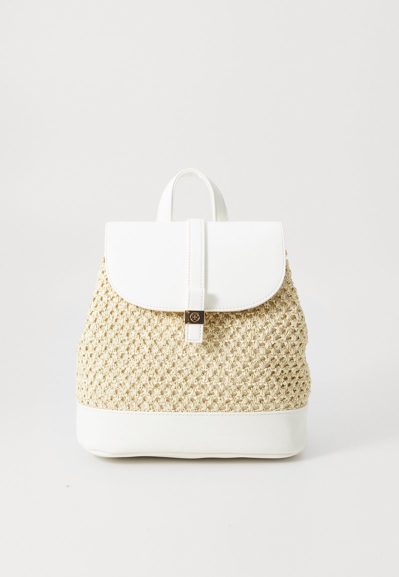 Sac à dos beige tressé avec rabat, poignée et base en cuir blanc, détail de fermoir doré à l'avant ; posé sur un fond clair uni.