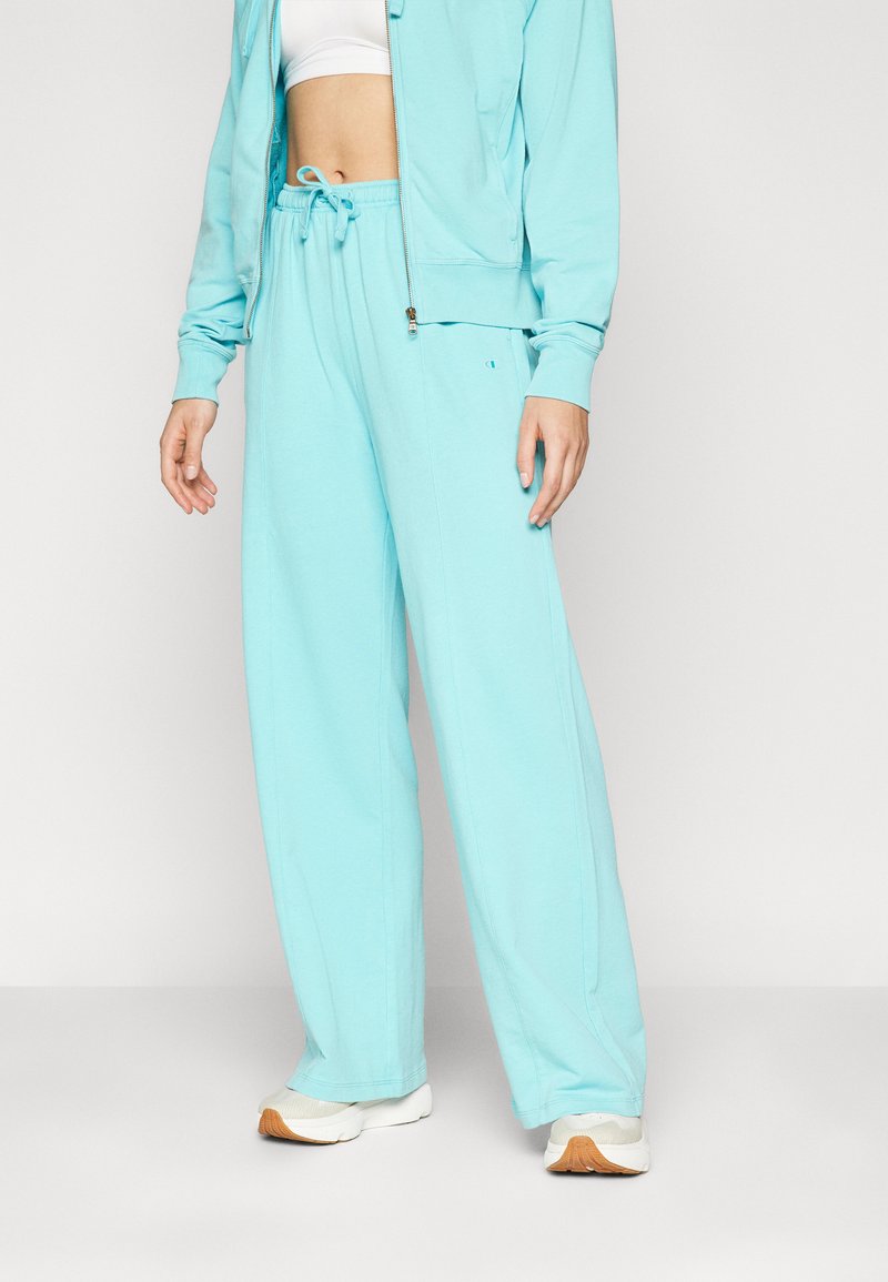 Ανοιχτό μπλε παντελόνια jogger από μαλακό ύφασμα με μέση με κορδόνι και πλαϊνές τσέπες, διαθέτοντας χαλαρή εφαρμογή και ελάχιστους διαφημιστικούς λογότυπους.