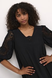 Vestido negro con mangas abullonadas de encaje que presentan intrincados patrones florales. Diseño con escote en V que resalta el borde de encaje en el escote y las mangas.