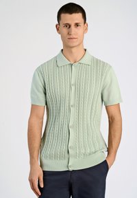 Kurzarm-Kabelstrick-Cardigan in Pastellgrün, mit kragenförmigem Ausschnitt und fünf Knopfverschluss, sowie geripptem Saum und Bündchen.