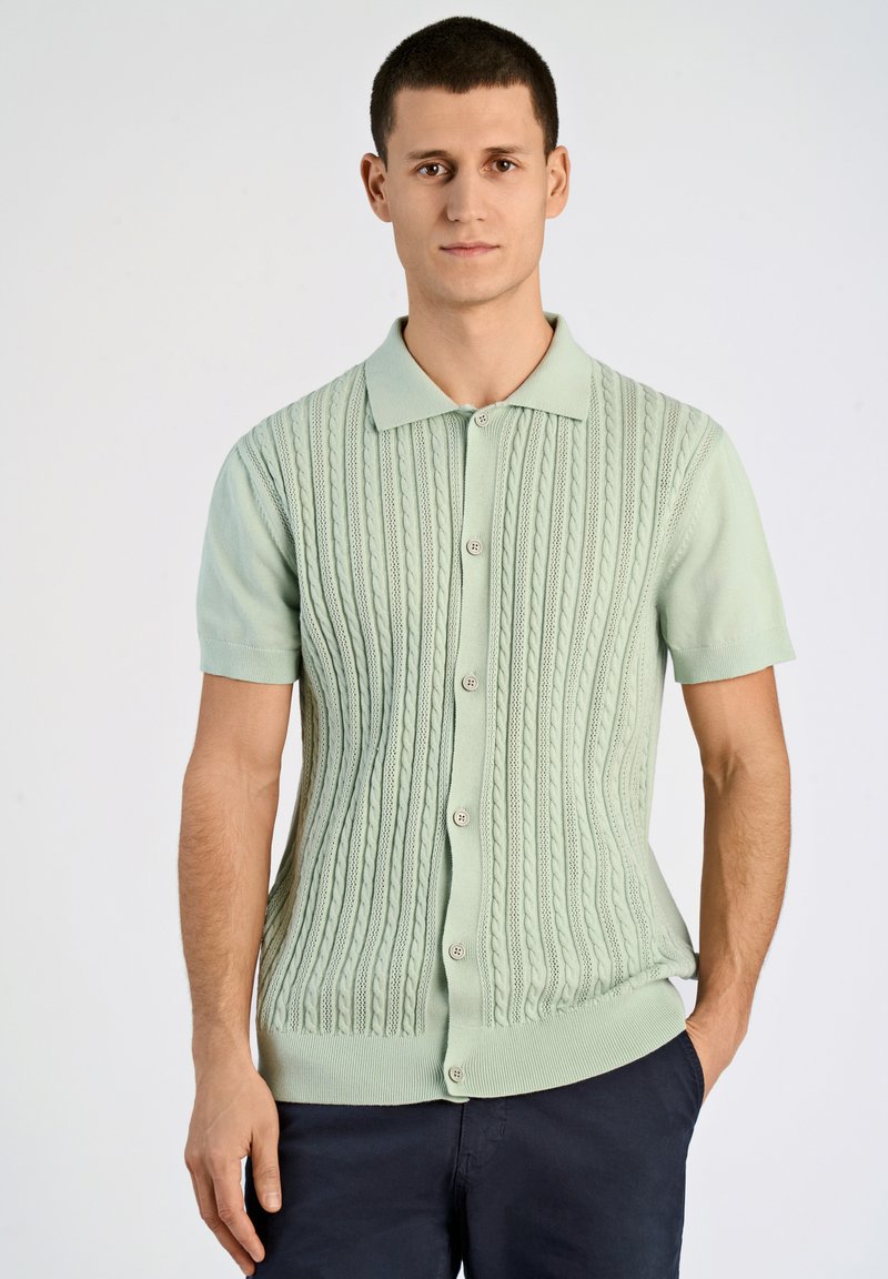 Kurzarm-Kabelstrick-Cardigan in Pastellgrün, mit kragenförmigem Ausschnitt und fünf Knopfverschluss, sowie geripptem Saum und Bündchen.